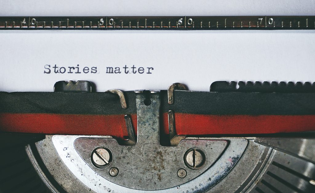 Closeup of a typewriter with the text "Stories matter" written on a white piece of paper