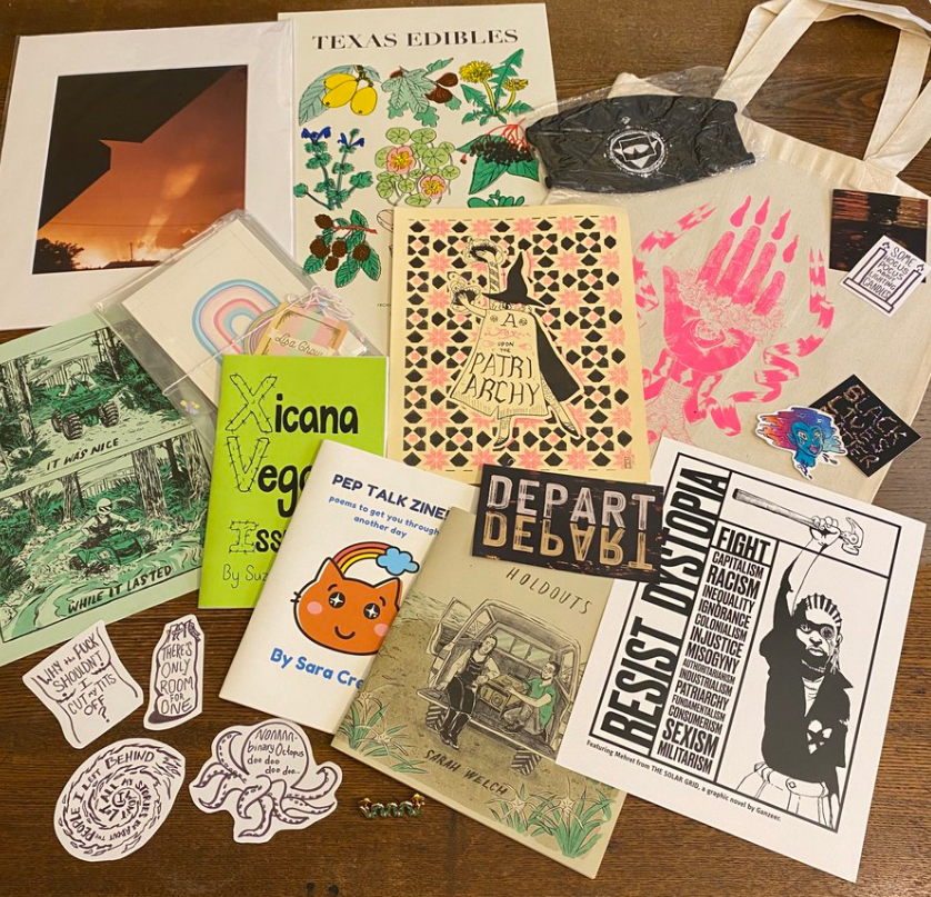 Photo of the collection of art, zines, and other goodies included in the Queer Climate Apocalypse Survival Kit